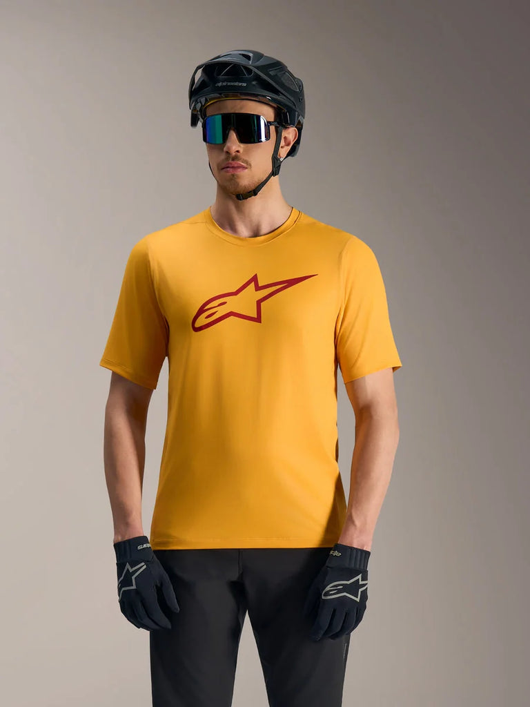 Orange A-Dura Ride Short Sleeve Jersey featuring a red Astars logo, styled with a mountain bike helmet and gloves.