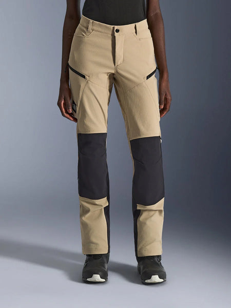 Alpinestars Woman Stella Flex-AST Explorer Pants, Women's Motorcycle Pants, Aluminum Black, front view on model, featuring sandy tan fabric with prominent black ripstop panels on the knees and lower legs, zippered pockets, adventure touring style