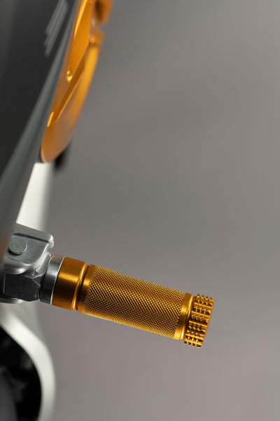 LighTech FTP100ORO single footpeg installed, gold opposite-side view; adapter, pin, original mounting bracket, motorcycle and other accessories are not included.